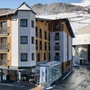a large white building next to a building at Glanz & Glory Hotel in Sölden
