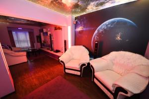 a living room with two chairs and a planet at Ket Apartments in Galaţi