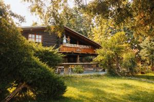 a log cabin with two people on the balcony at Cabañas swissminiatur in Cacheuta