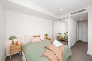 a bedroom with a large green bed and a mirror at 1011 - First Light 2BR with Ocean Views - Prime Location in Newcastle