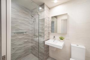 a bathroom with a shower and a sink and a toilet at 1011 - First Light 2BR with Ocean Views - Prime Location in Newcastle +17 photos