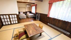 a living room with a table and a bedroom at 森のうた Morinouta Forest Stay in Nikko in Nikko