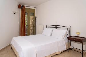 a bedroom with a white bed and a table at Panorama Villa Sitia in Sitia +23 photos