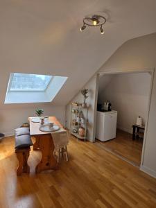 a living room with a table and a skylight at Les appartements du Marché in Dinan