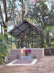 a pavilion in a park with clothes hanging from trees at Shankars Resort in Guwahati +2 photos