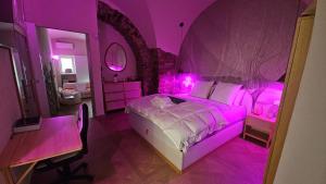 a purple bedroom with a bed with pink lighting at Casa Vacanza Zhurian in Ginestra