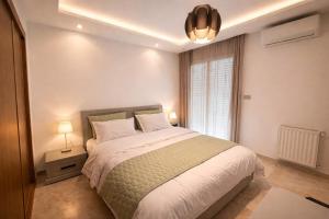 a bedroom with a large bed and a window at Appt lux Hammamet Nabeul in Hammamet Nord