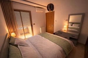 a bedroom with a bed and a mirror at Appt lux Hammamet Nabeul in Hammamet Nord