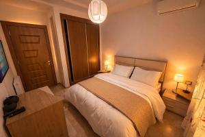 a bedroom with a bed and a table and two lamps at Appt lux Hammamet Nabeul in Hammamet Nord +16 photos