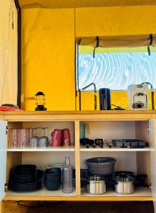 a shelf filled with pots and pans and dishes at Glamping Safaritent 4 persoons in Hindeloopen