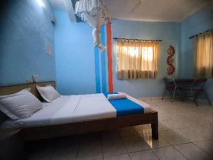 a bedroom with a bed in a blue room at L'Hotel 5-5 in Mahajanga +4 photos