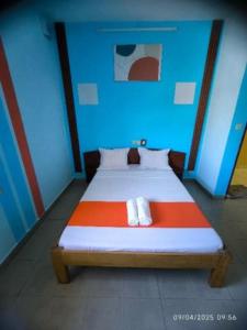 a bed in a room with a blue and red at L'Hotel 5-5 in Mahajanga