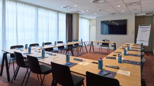 a conference room with tables and chairs and a screen at Campanile PRIME - Nanterre La Défense in Nanterre