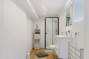 a white bathroom with a toilet and a sink at Ferienwohnungen Hirsch Schwarzwald in Bad Dürrheim +75 photos