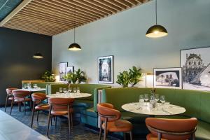 a restaurant with tables and chairs and pictures on the walls at Campanile PRIME - Nanterre La Défense in Nanterre