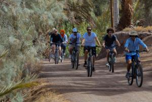 a group of people riding bikes down a dirt road at Heritage House Skoura in Skoura