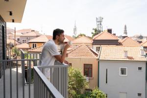 a man standing on a balcony looking at the city at Host Wise - Marquesa Palace in Porto