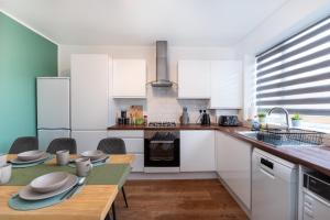 a kitchen with white cabinets and a wooden table at 3 bed house, Free parking 9ppl in Pleasley