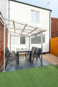 a patio with a table and chairs and a building at 3 bed house, Free parking 9ppl in Pleasley