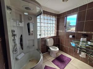 a bathroom with a tub and a toilet and a sink at Emakhaya B&B in Mthatha +44 photos