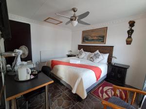 a bedroom with a bed and a ceiling fan at Emakhaya B&B in Mthatha