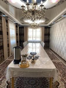 a dining room with a white table and a chandelier at Daniel guesthouse in Kochkorka