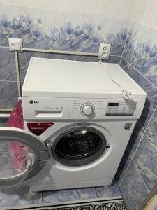 a washing machine sitting in a bathroom next to a wall at Daniel guesthouse in Kochkorka
