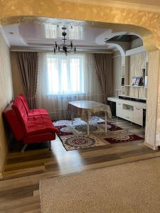 a living room with a red chair and a table at Daniel guesthouse in Kochkorka +6 photos