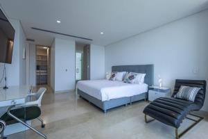 a bedroom with a bed and a desk and a chair at Tropical villa w pool & dock access u501 in Barú