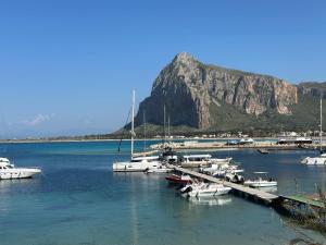 a bunch of boats docked in a harbor with a mountain at Il vecchio e il mare in San Vito lo Capo