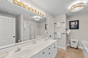 a white bathroom with a sink and a large mirror at Marsh Breeze Hideaway at Masters Place in Pawleys Island +13 photos