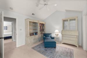 a living room with a blue chair and a book shelf at Marsh Breeze Hideaway at Masters Place in Pawleys Island