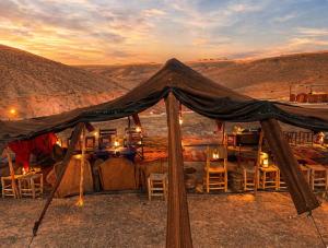 a tent in the desert with tables and chairs at Campement authentique désert d Agafay in El Moukhtar