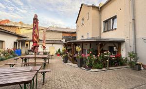 a patio with benches and umbrellas and a building at Penzion u Fouska in Chodov