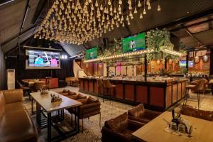 a restaurant with tables and chairs and a bar at asar Upper House Morjim Beach by Orion Hotels in Morjim