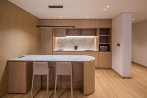 a kitchen with a counter with chairs around it at ILLITE Hotel in Yŏngdong