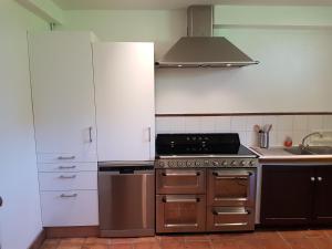 a kitchen with a stove and a sink in it at Moulin de Lossulien in Le Relecq-Kerhuon