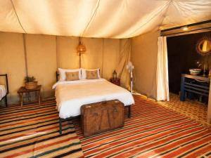 a bedroom with a bed in a tent at Campement authentique désert d Agafay in El Moukhtar