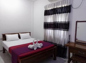 a bedroom with a bed with a stuffed animal on it at Ceylon Seaway Villa in Trincomalee