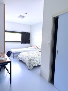 a white room with two beds and a table at JF Accueil & Formation in Cholet +10 photos