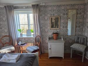 a bedroom with a bed and a table and a window at Hova Prästgård Bed & Breakfast in Hova