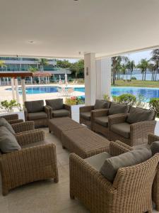 a patio with wicker chairs and couches next to a pool at Lake view in Brasília