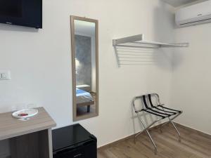 a room with a mirror and a chair and a table at Il vecchio e il mare in San Vito lo Capo