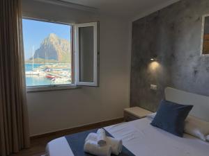 a bedroom with a window with a view of a harbor at Il vecchio e il mare in San Vito lo Capo