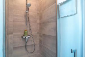 a shower with a shower head in a bathroom at Lumineux logement vue sur le port in Audierne