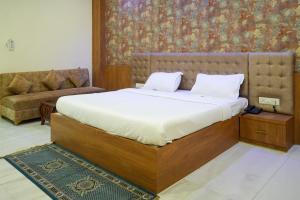 a bedroom with a bed and a couch at Lotus Resort in Raipur +16 photos