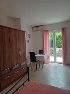 a bedroom with a table and a dining room at Studio Apartment Ivo in Cres