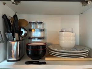 a kitchen counter with plates and utensils on a shelf at Lake view in Brasília
