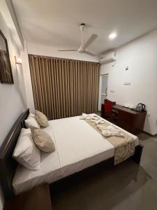 a bedroom with a bed and a desk at Solar Airport Hotel in Seeduwa