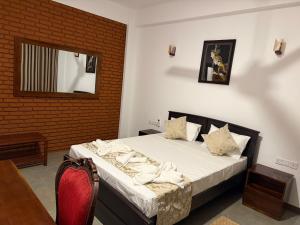a bedroom with a bed and a mirror on the wall at Solar Airport Hotel in Seeduwa